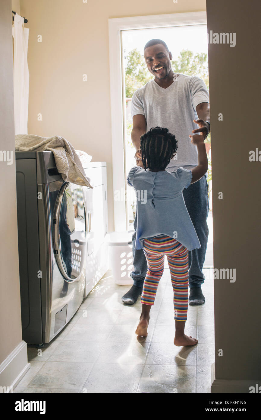 African American father and daughter doing laundry Stock Photo