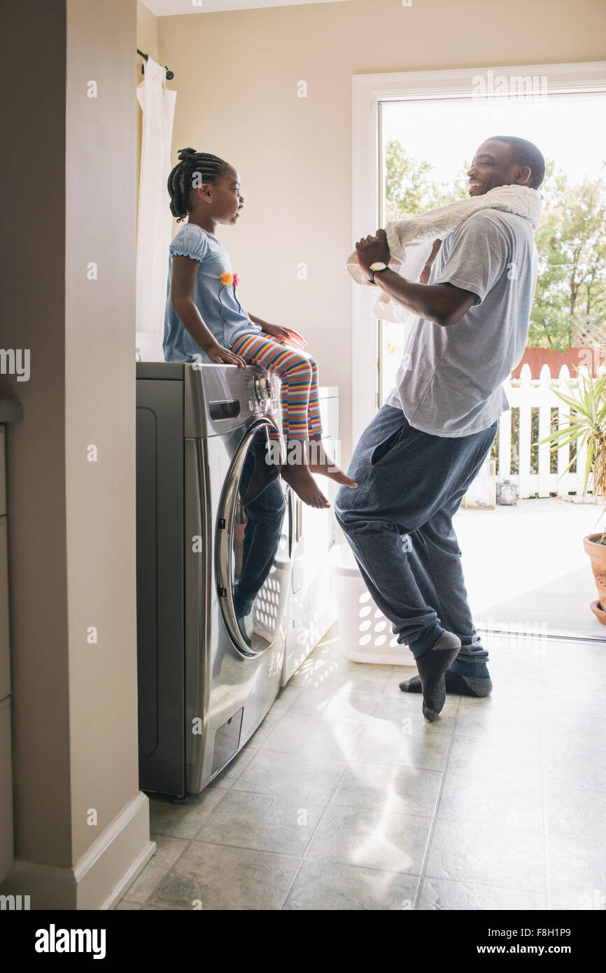 African American father and daughter doing laundry Stock Photo