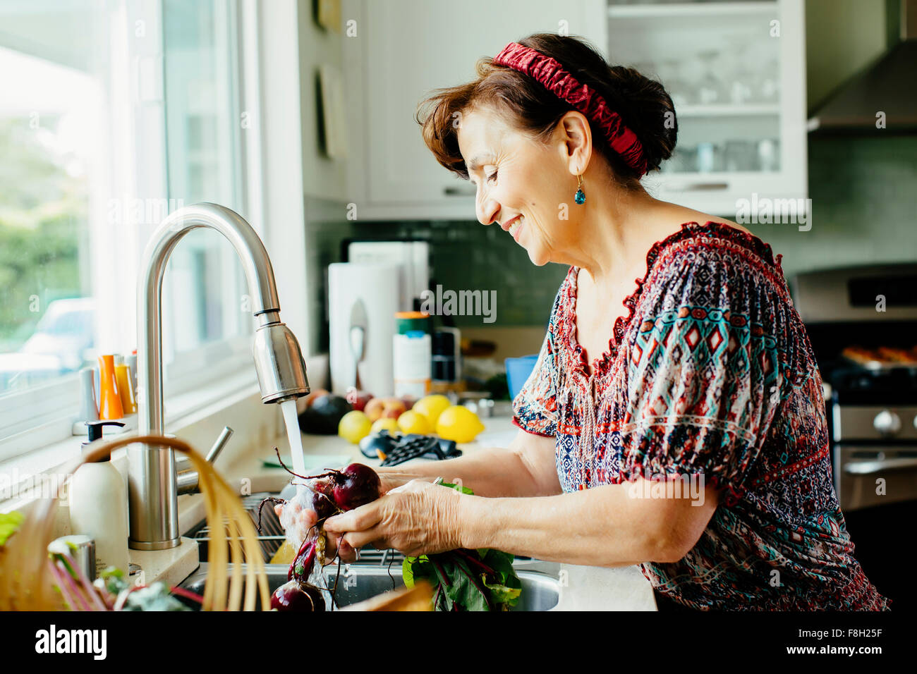 Caucasian woman washing vegetables in kitchen Stock Photo