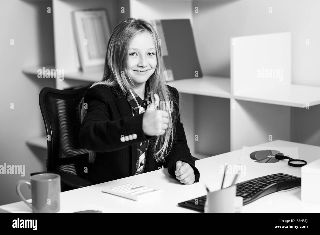 Little girl like business woman at the table Stock Photo