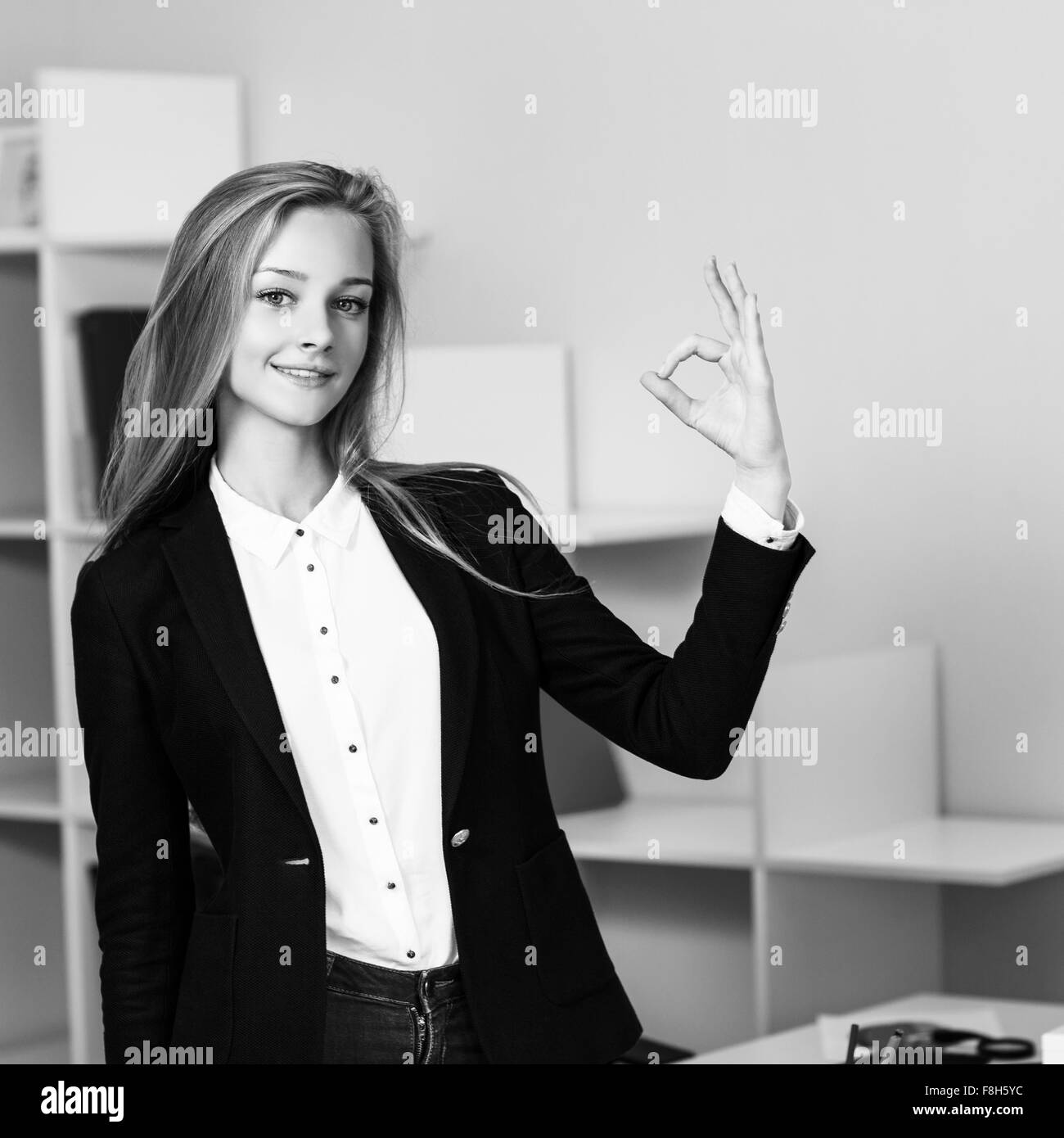 Young pretty business woman makes OK sign Stock Photo