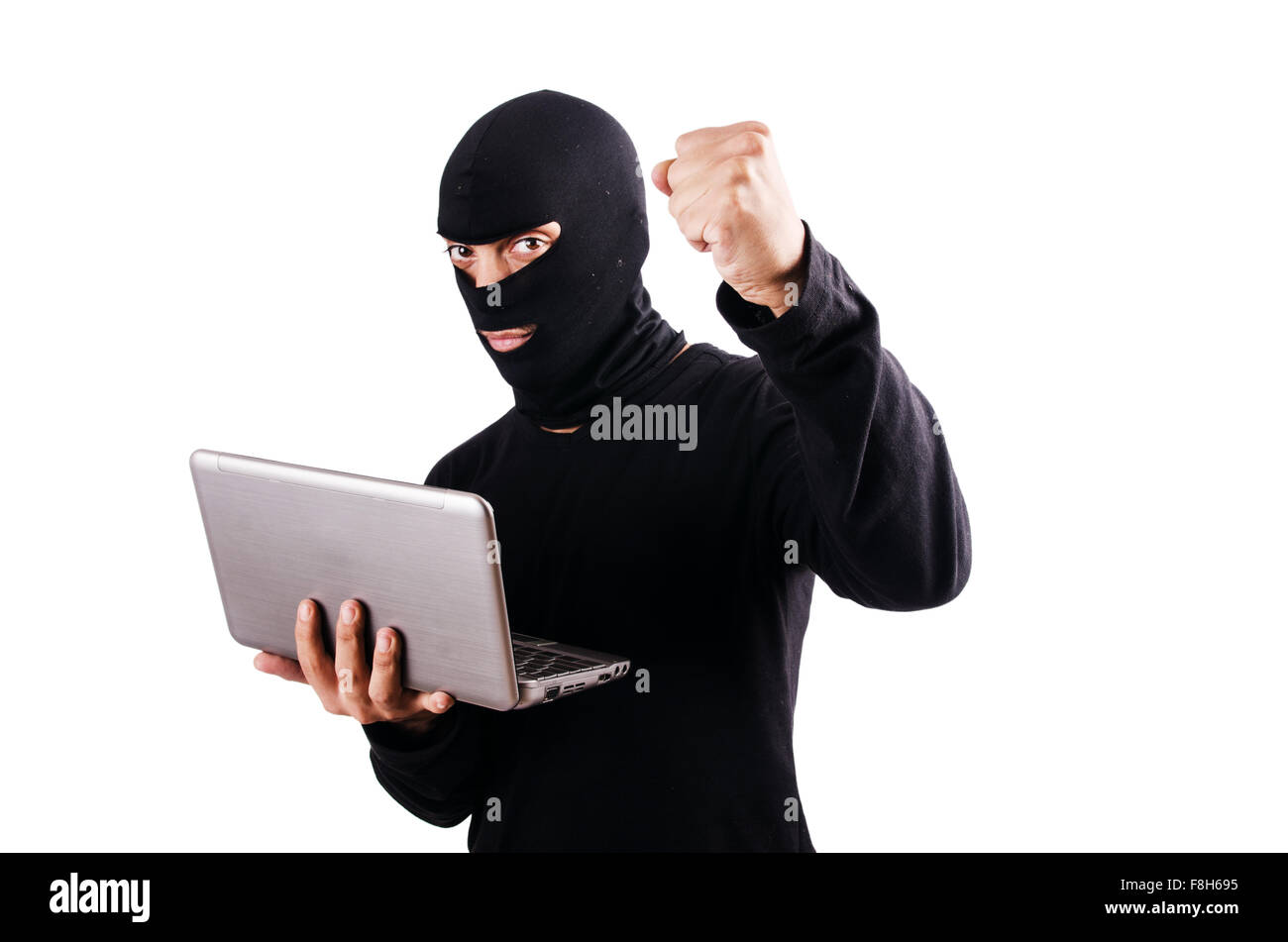 Hacker with computer wearing balaclava Stock Photo - Alamy