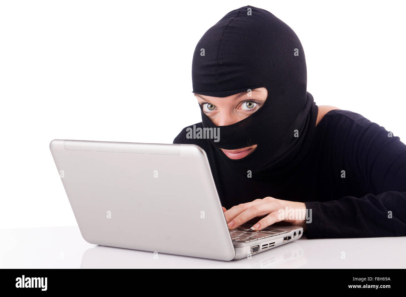 Hacker with computer wearing balaclava Stock Photo - Alamy