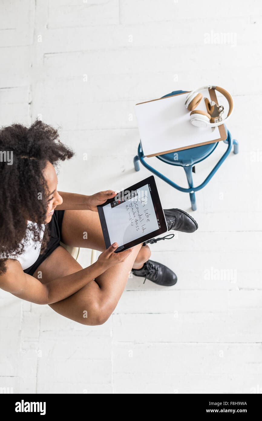 A young Afro-American woman using a tablet or iPad in a studio type setting Stock Photo