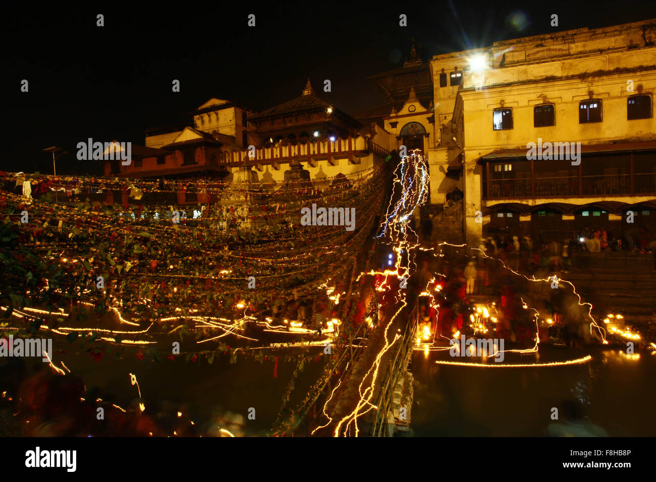 Kathmandu, Nepal. 10th Dec, 2015. Photo captured in long exposure shows Nepalese Hindu devotees carrying oil lamp to put on the Bagmati river to offer prayers during the Bala Chaturdashi Festival in Kathmandu, Nepal, Dec. 10, 2015. On this day, worshippers scatter seven types of grain known as 'Sat biu' honouring the departed along a route at the temple. © Pratap Thapa/Xinhua/Alamy Live News Stock Photo
