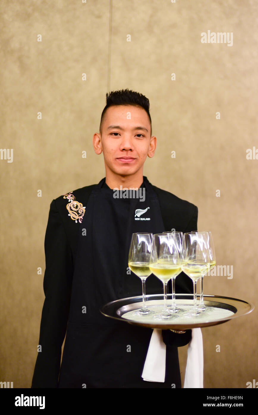 Asian male waiter serving drinks. Stock Photo