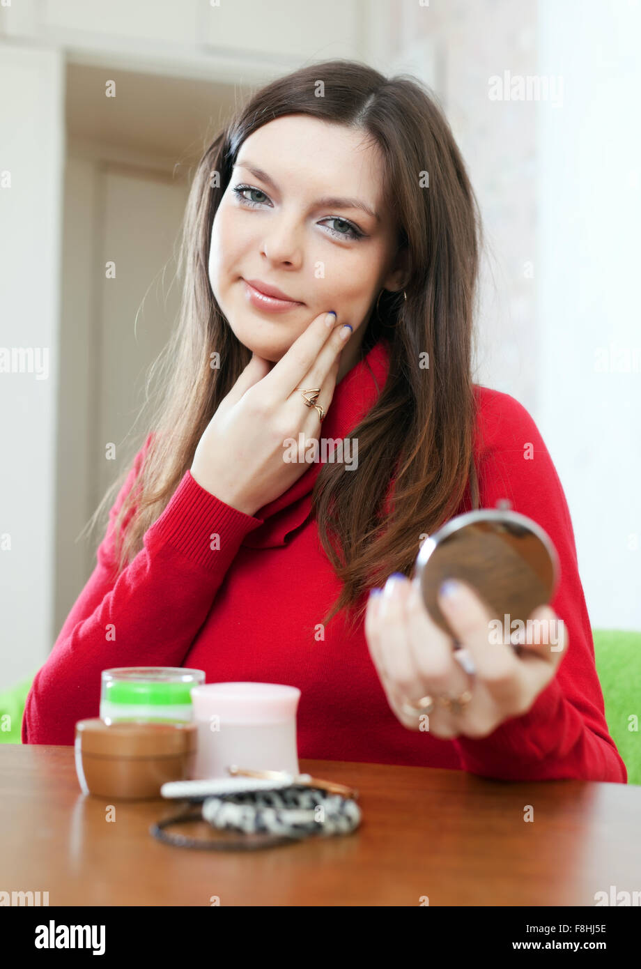 Young woman looks on face in mirror Stock Photo Alamy