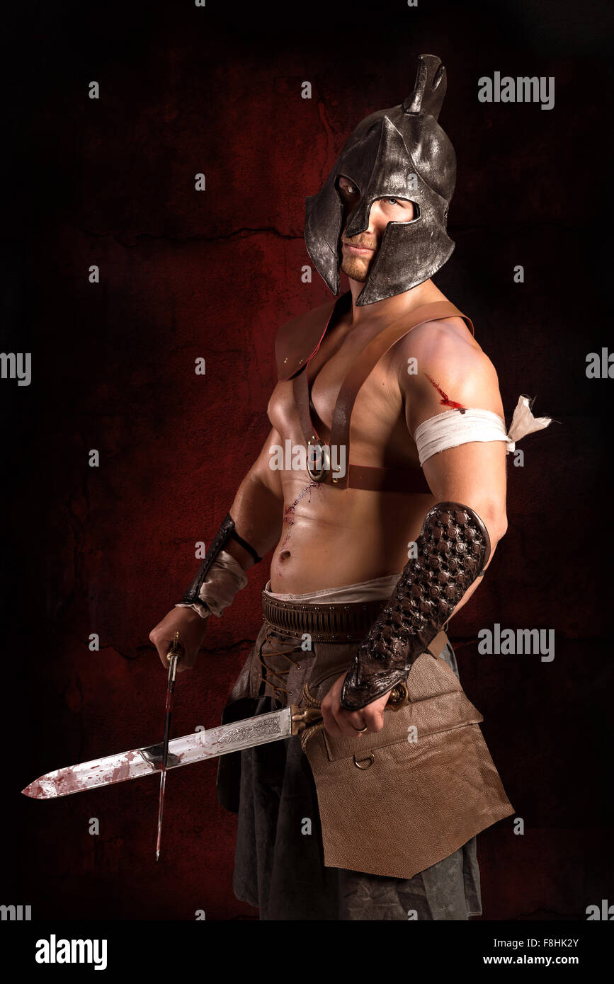Gladiator posing isolated in a dark background Stock Photo - Alamy