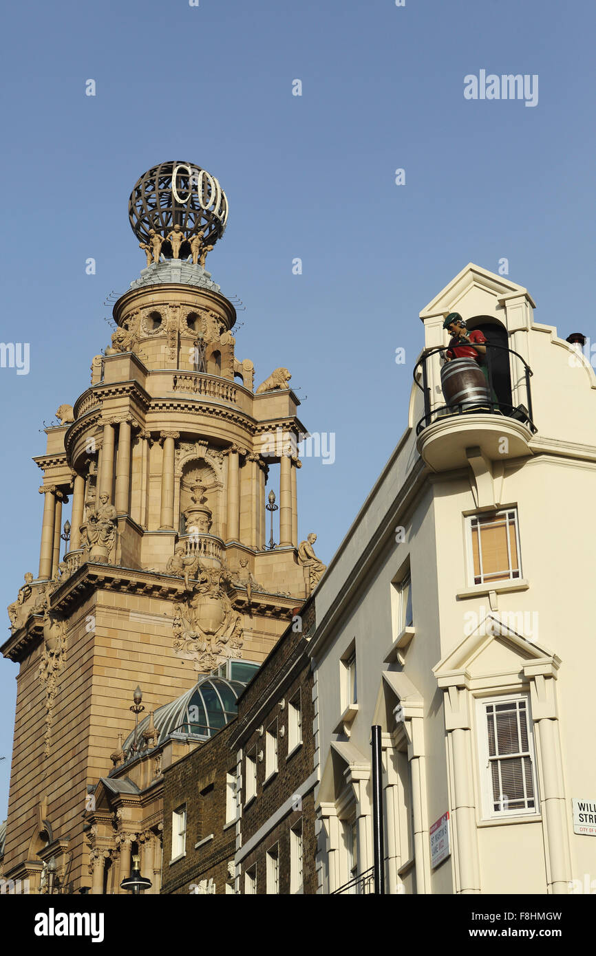 A figure with a beer barrel on the roof of the Chandos pub, next to the globe of the London Coliseum West End theatre in London. Stock Photo