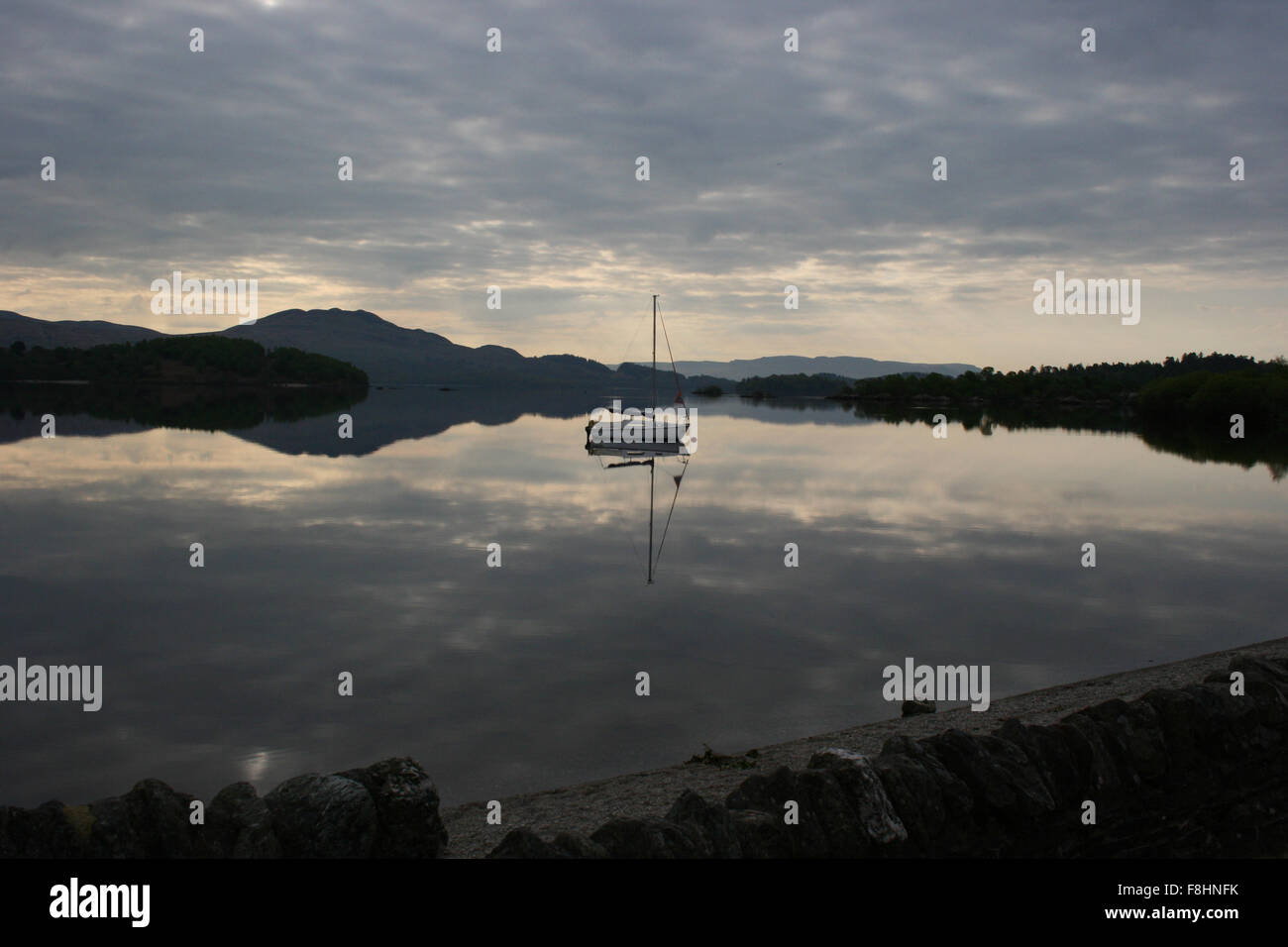 Dinghy reflected on Loch Lomond Stock Photo Alamy