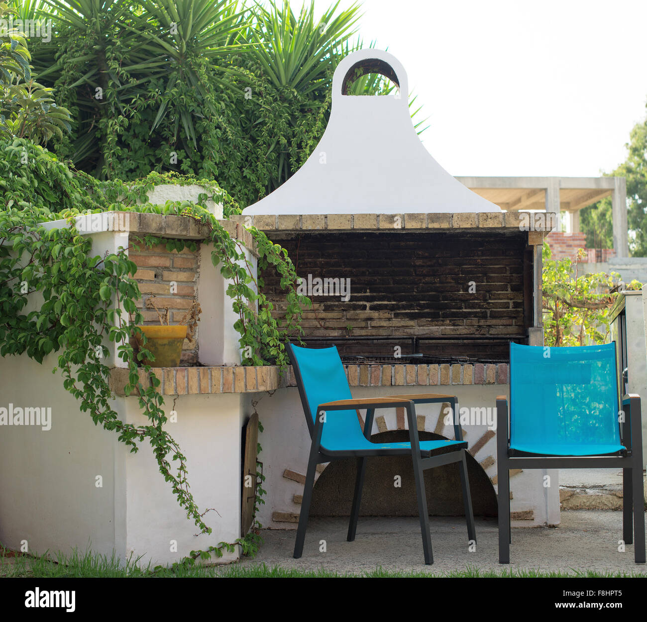 Outdoor Fireplace With Chairs On The Backyard Stock Photo