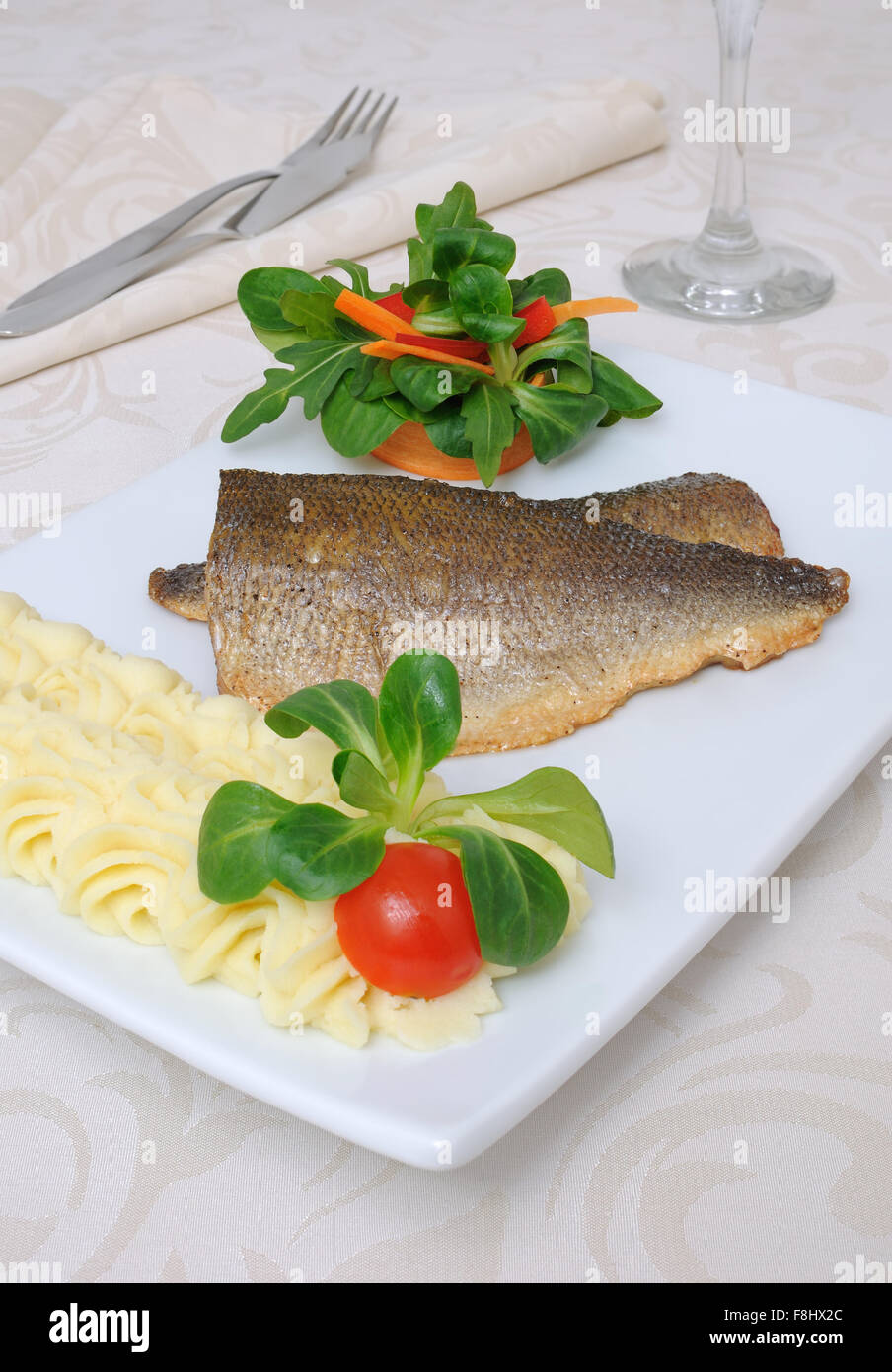 Baked fillet of sea bass with vegetables and mashed potato mix Stock