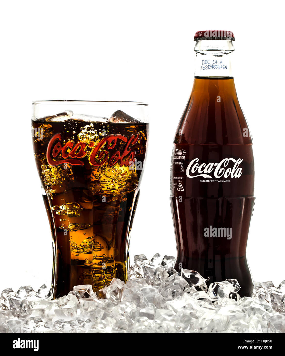Coca-Cola in Classic Retro  Branded Glass with Classic Bottle on Ice over a white background Stock Photo