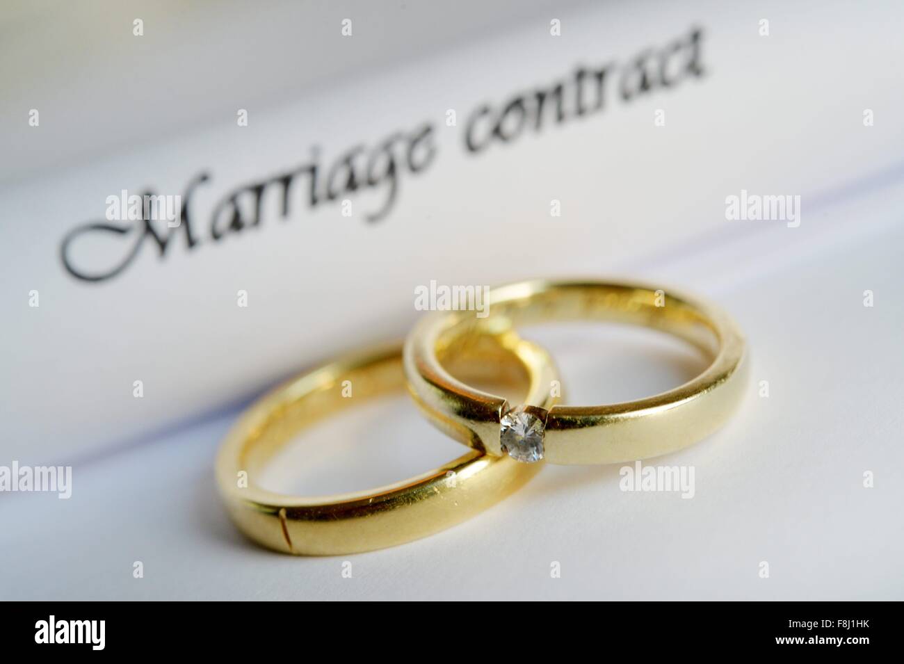 Two rings are laying on a marriage contract, Germany, city of Osterode, 09. December 2015. Photo: Frank May Stock Photo