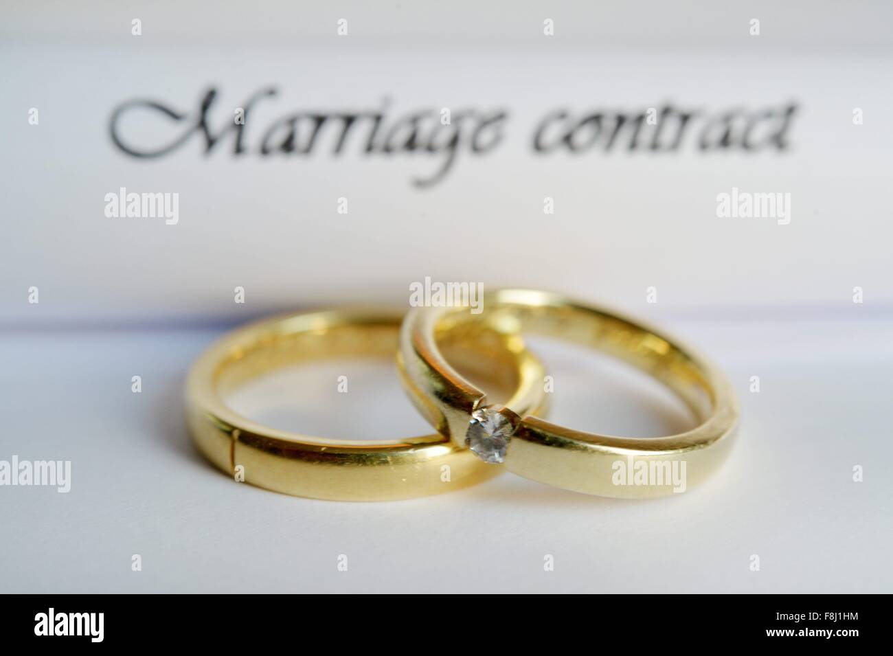 Two rings are laying on a marriage contract, Germany, city of Osterode, 09. December 2015. Photo: Frank May Stock Photo