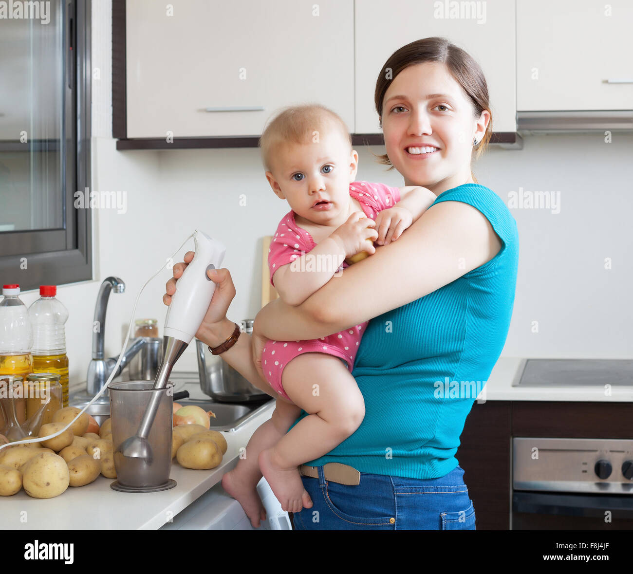 Happy mother with child  in kitchen at home Stock Photo