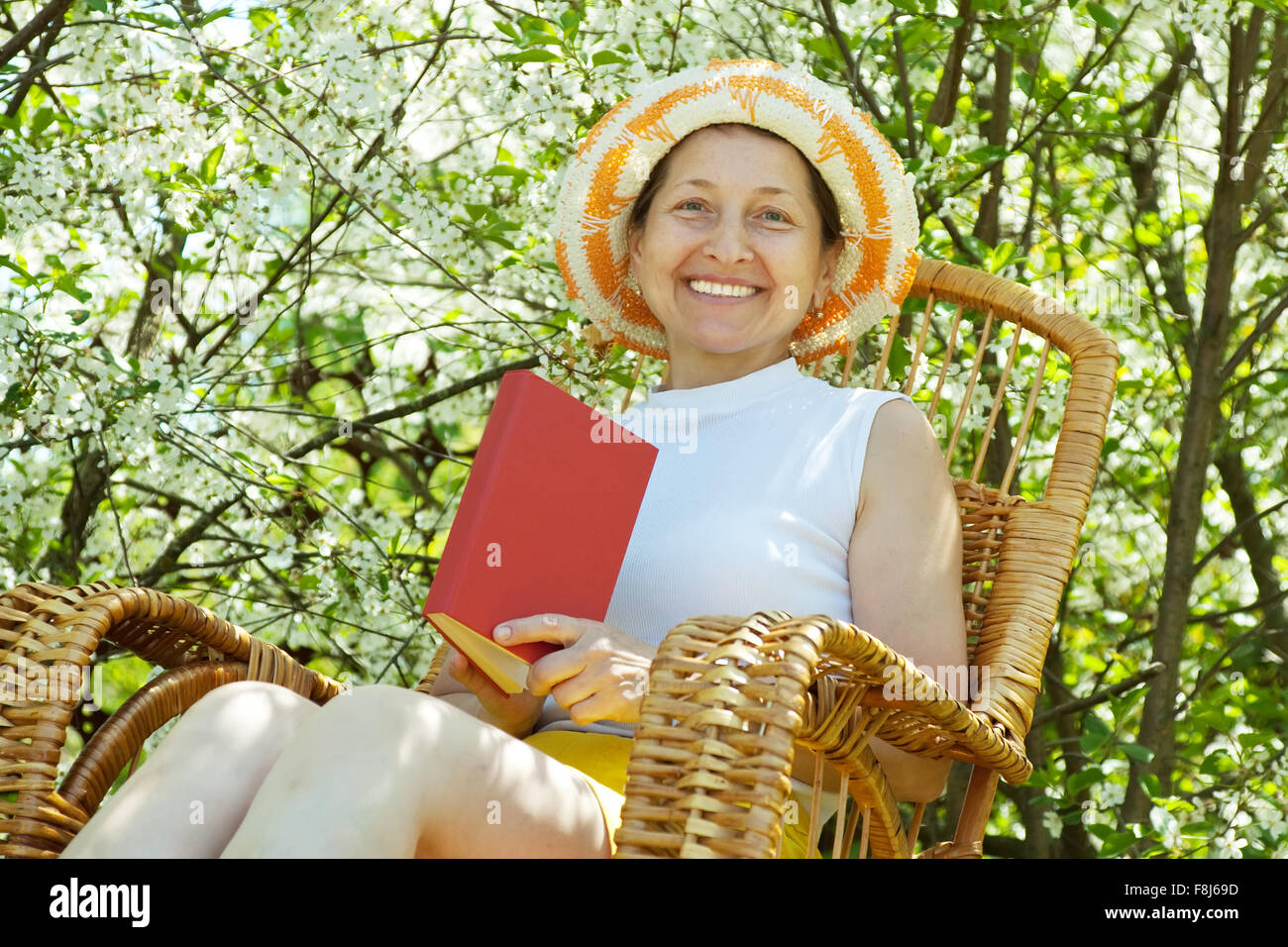 Happy mature woman relaxing in bloom garden Stock Photo - Alamy