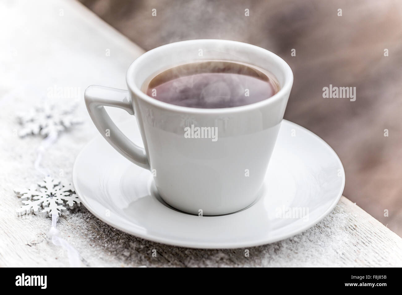 Hot tea in the cup on snow-capped wooden table Stock Photo