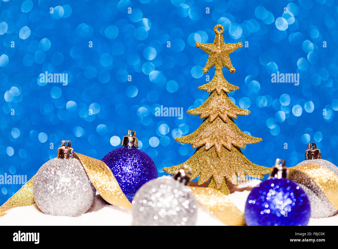 Golden Christmas tree on glitter blue background Stock Photo - Alamy
