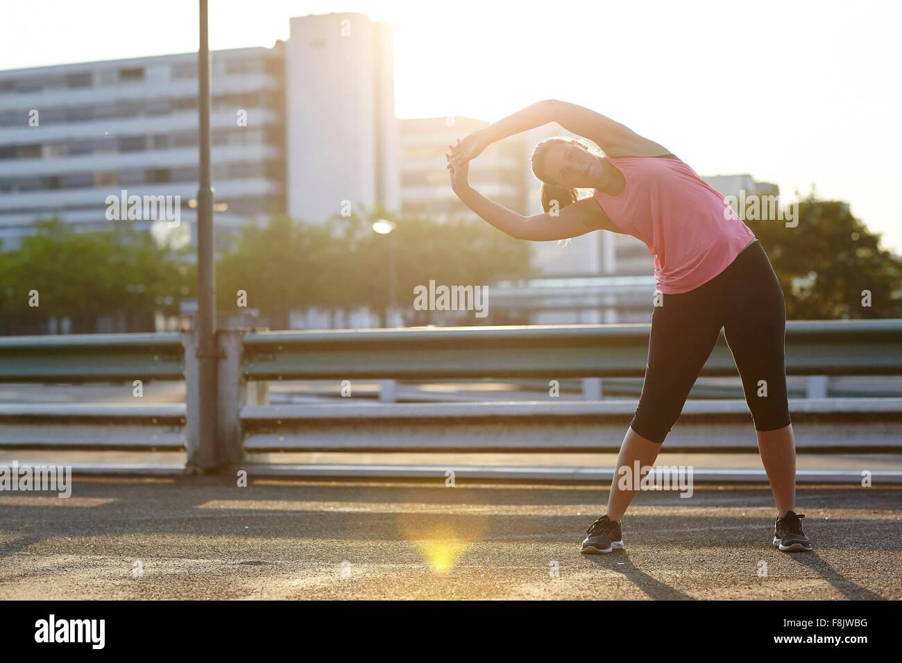 Young female runner warming up on rooftop Stock Photo Alamy
