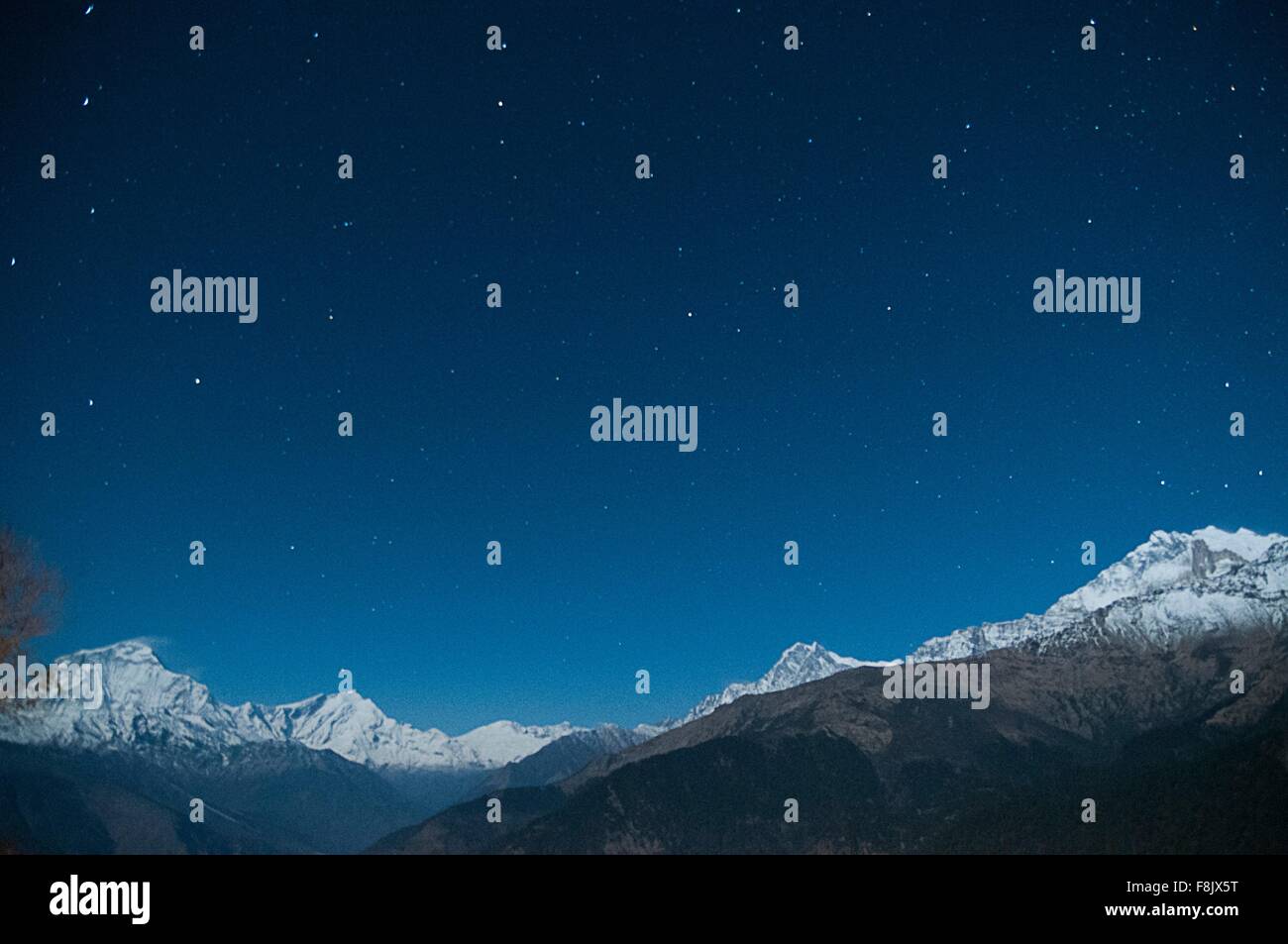 Snow capped mountain range under starry night sky, Nepal Stock Photo ...