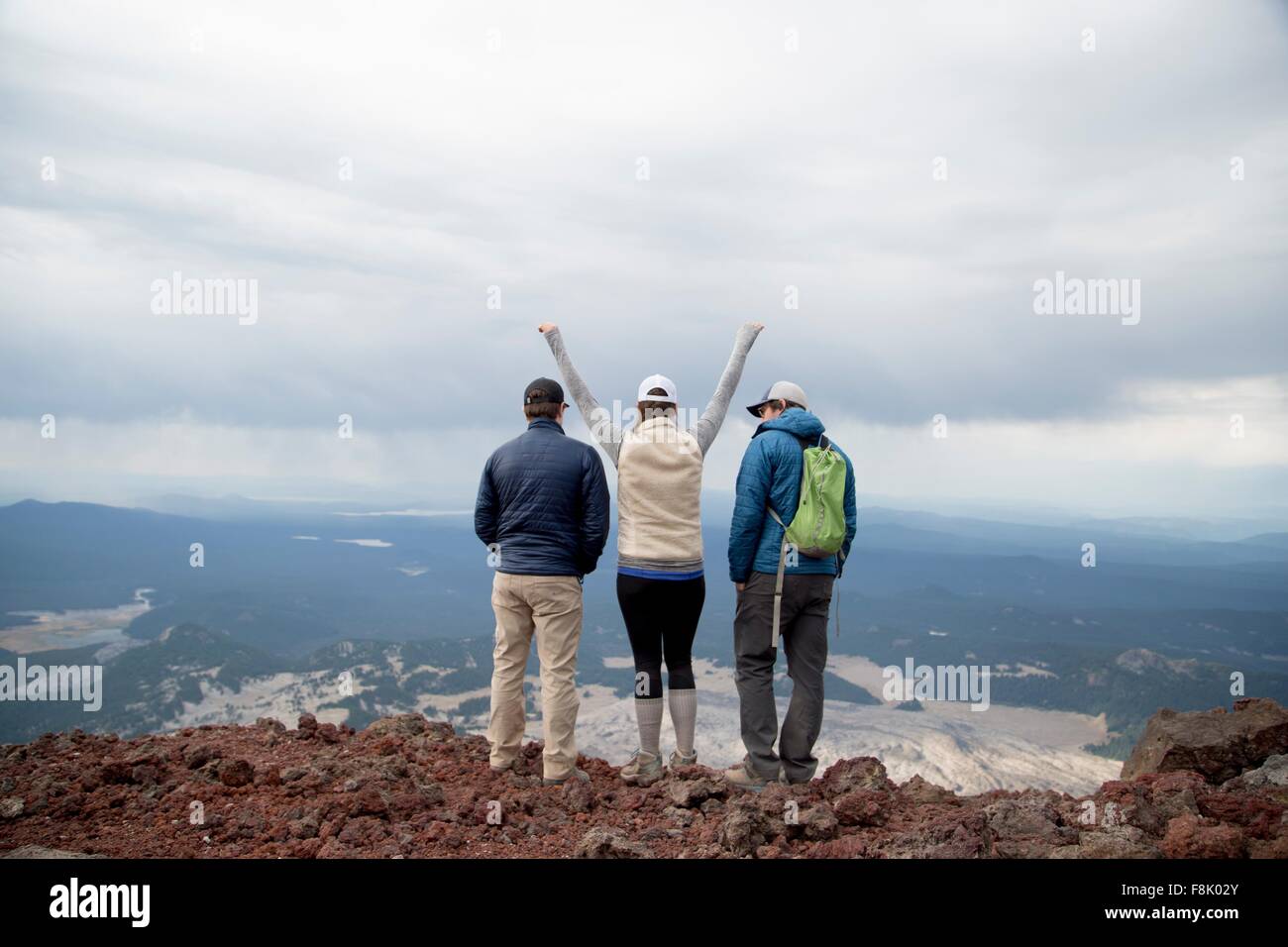 Three friends standing at the summit of South Sister volcano, looking at view, Bend, Oregon, USA Stock Photo