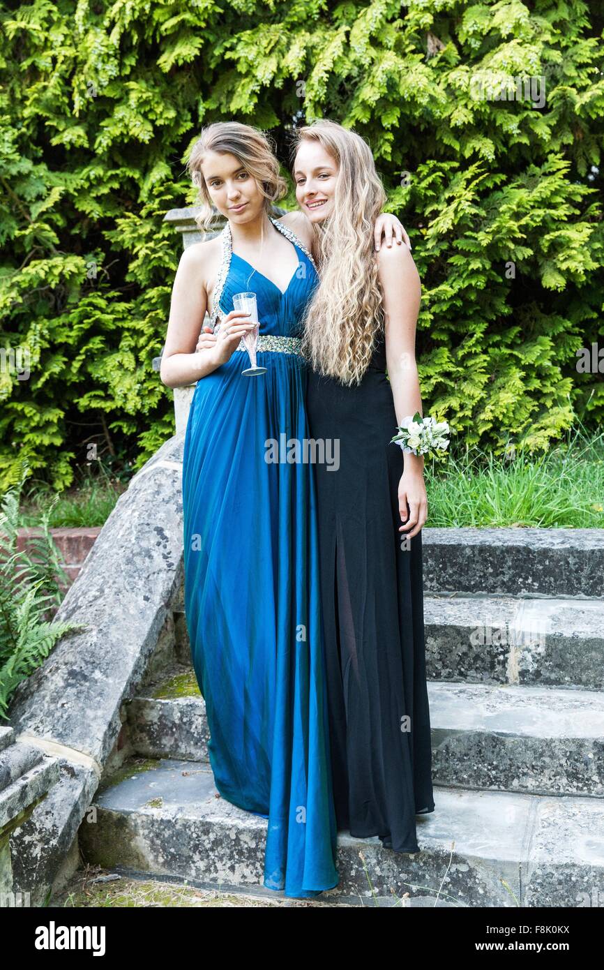 Teenage girls wearing prom dresses holding champagne flute looking at camera smiling Stock Photo