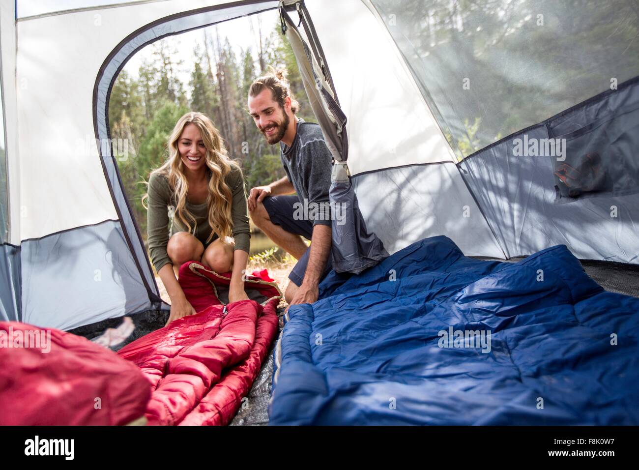 Happy young couple looking into tent, Lake Tahoe, Nevada, USA Stock Photo