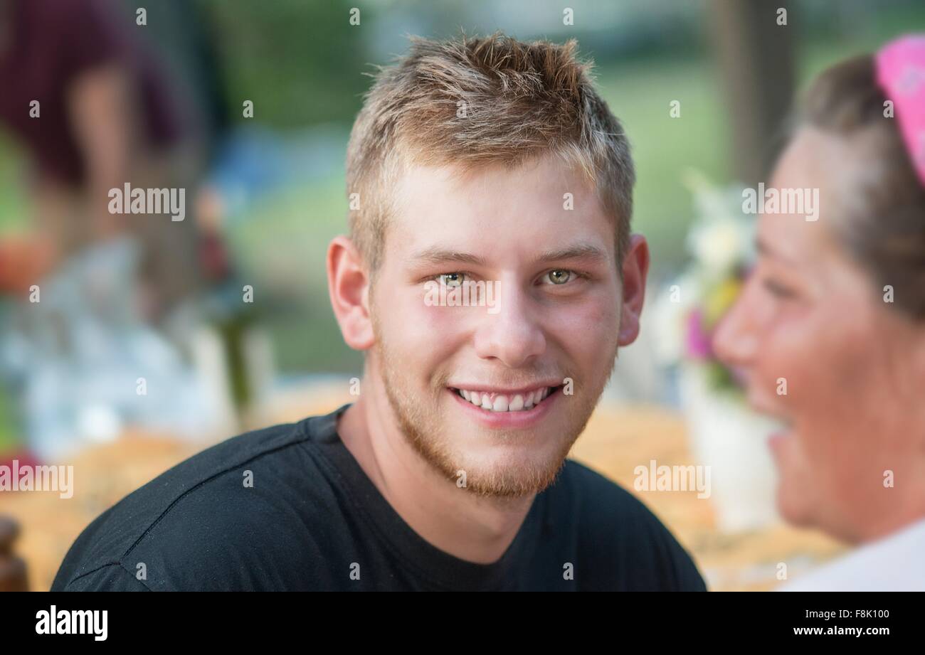 Portrait of young man at social gathering looking at camera smiling Stock Photo