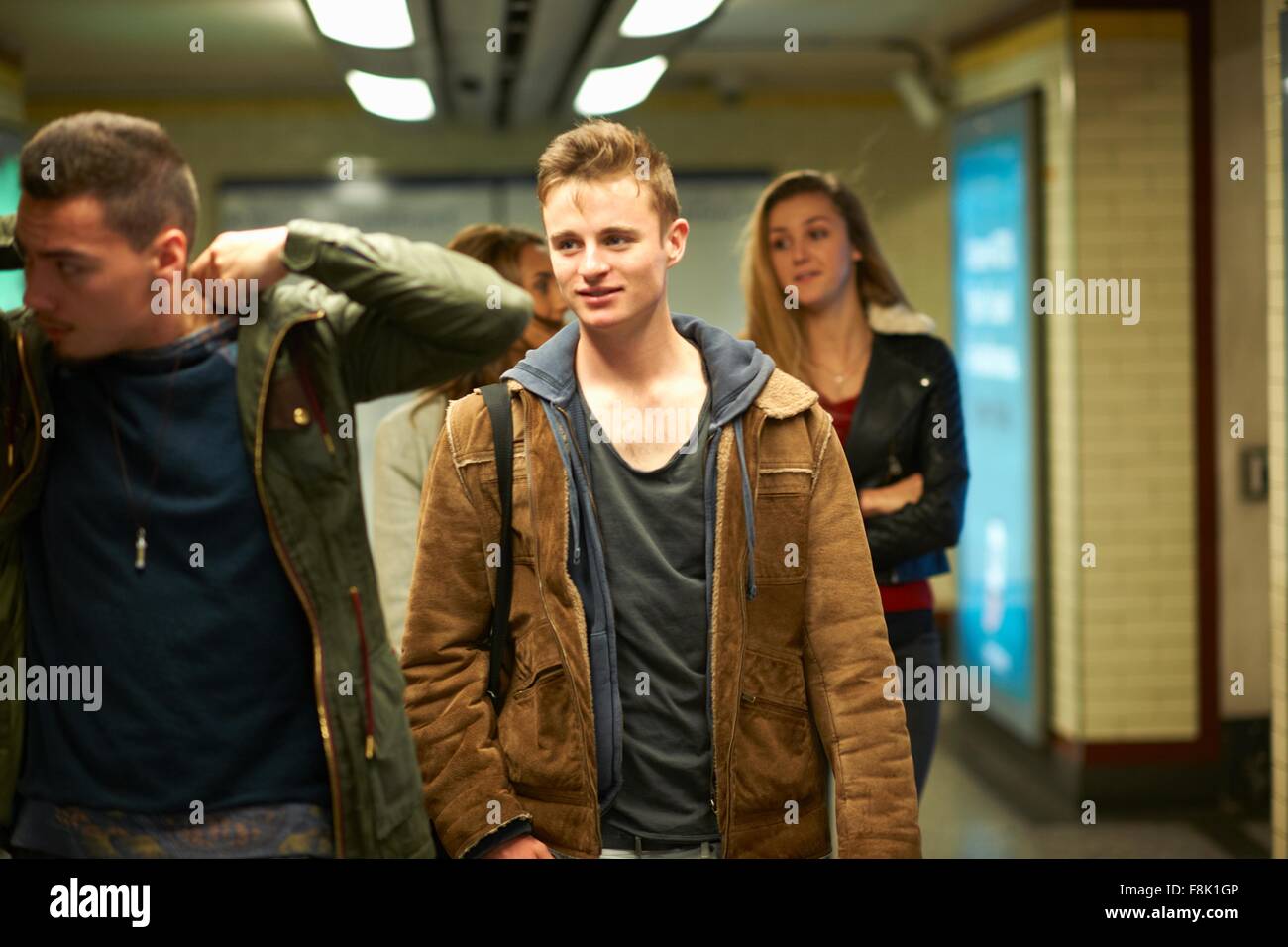 Four young adult friends walking through London underground station, London, UK Stock Photo