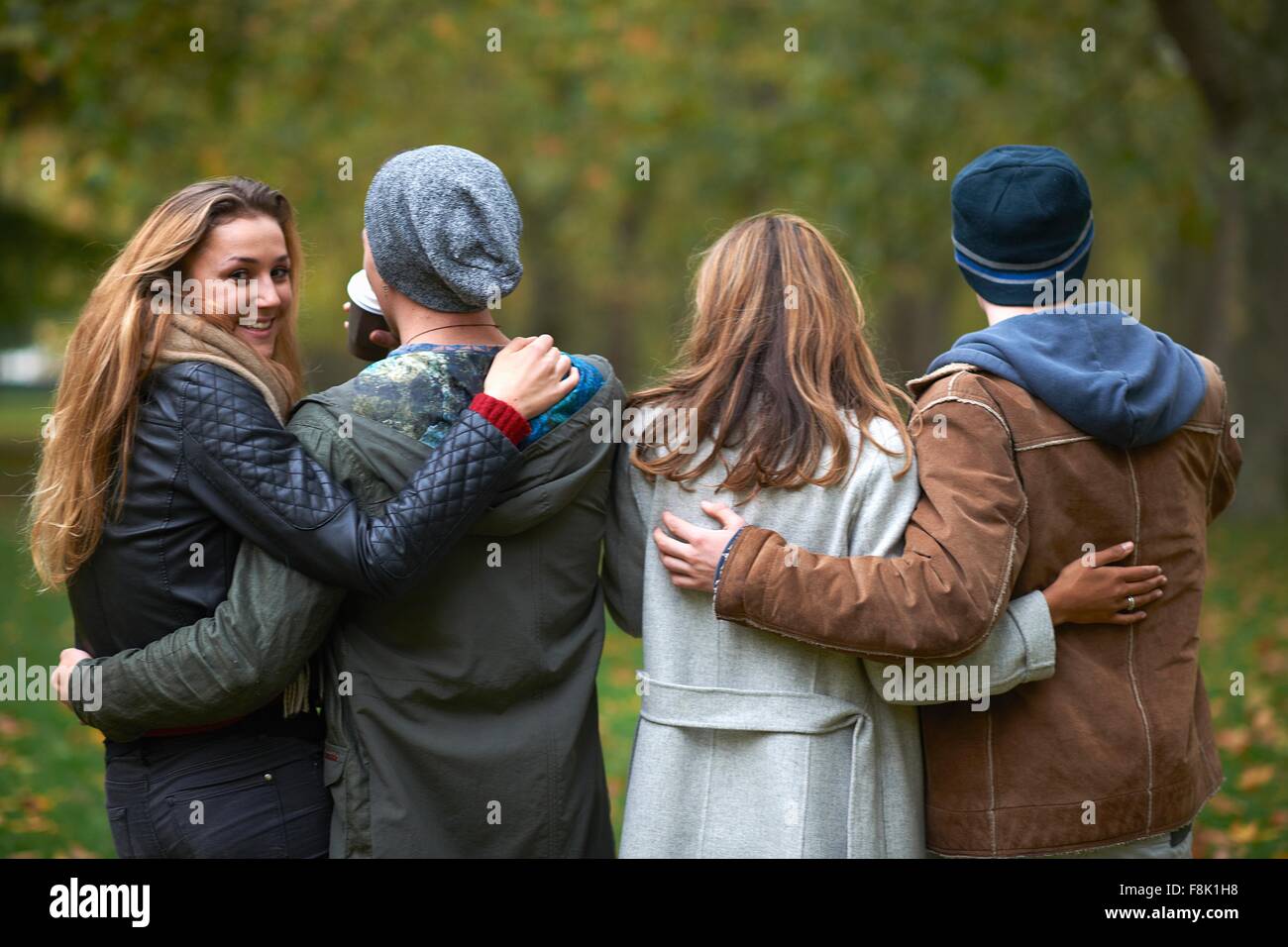 Rear view of two young couples walking in autumn park Stock Photo - Alamy