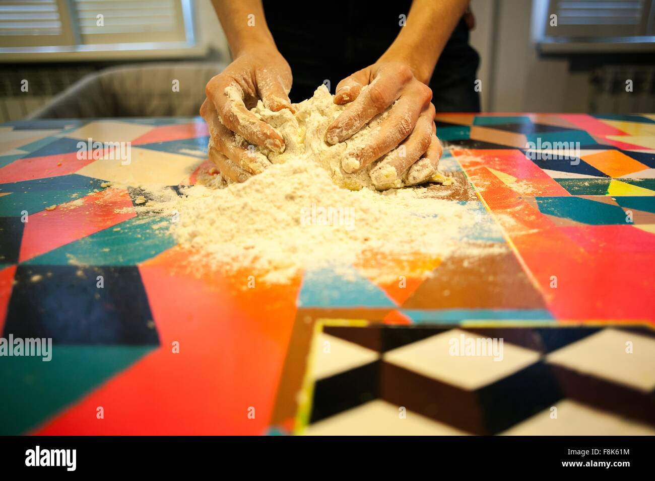 Close up of womans hands shaping dough on kitchen table Stock Photo