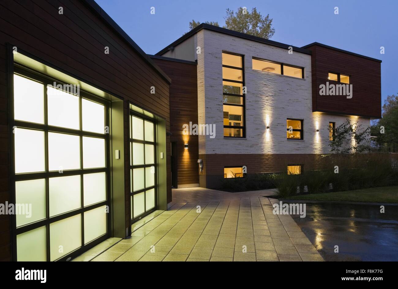 Illuminated two car garage of modern cubist style residential home at dusk, Quebec, Canada Stock Photo