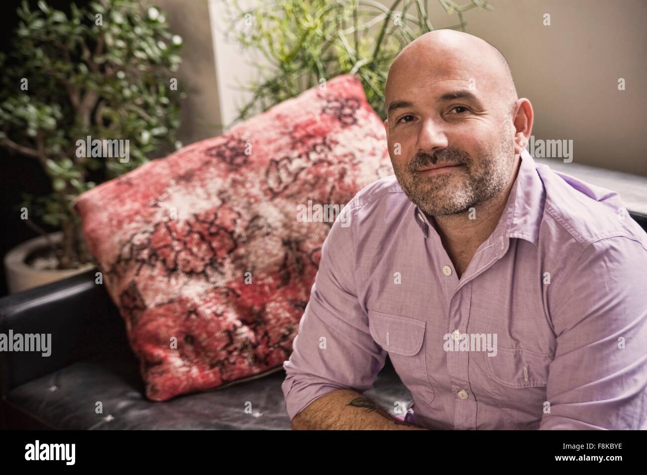 Portrait of confident mature man sitting on sofa Stock Photo
