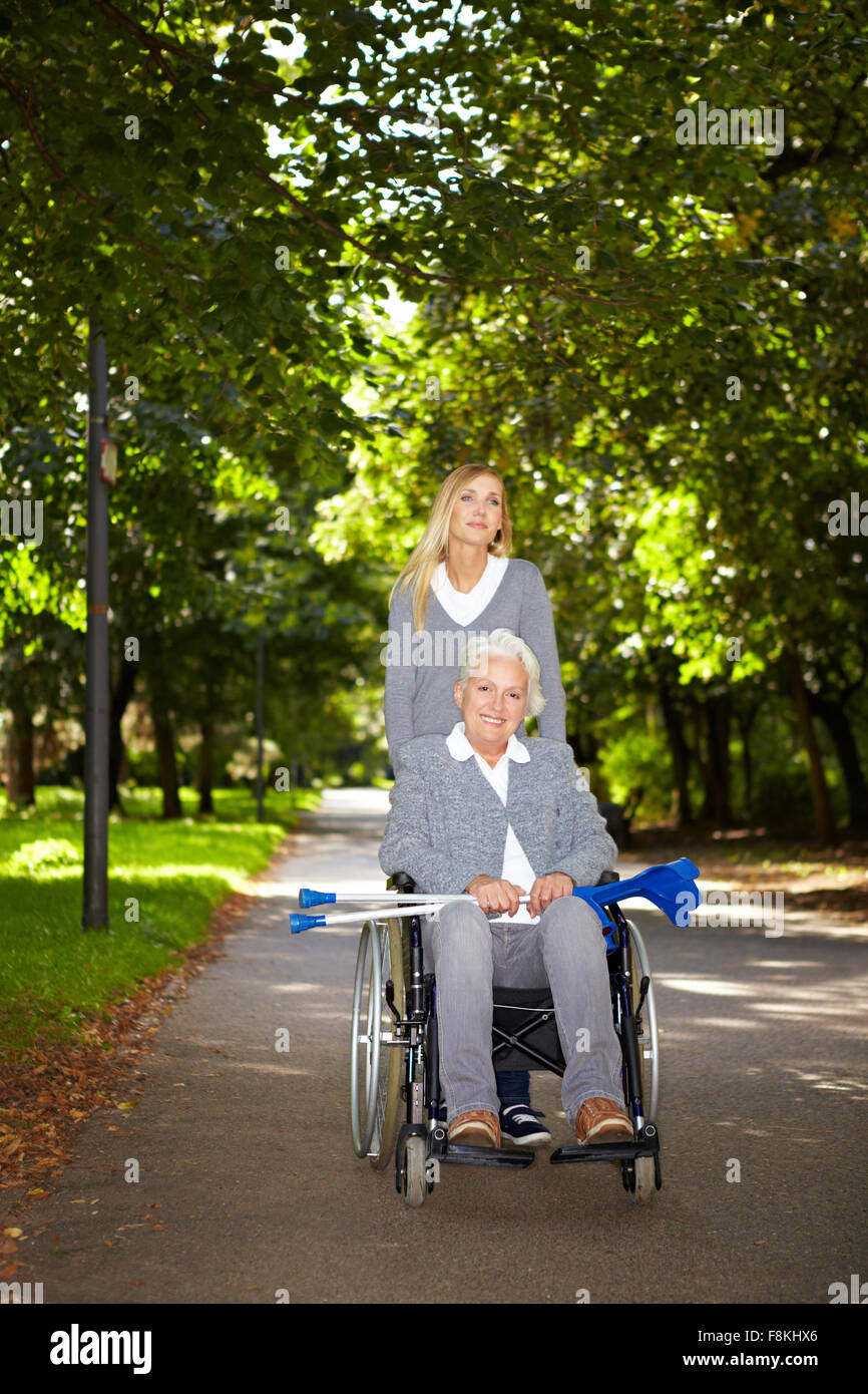Happy woman in wheelchair with young woman in nature Stock Photo - Alamy
