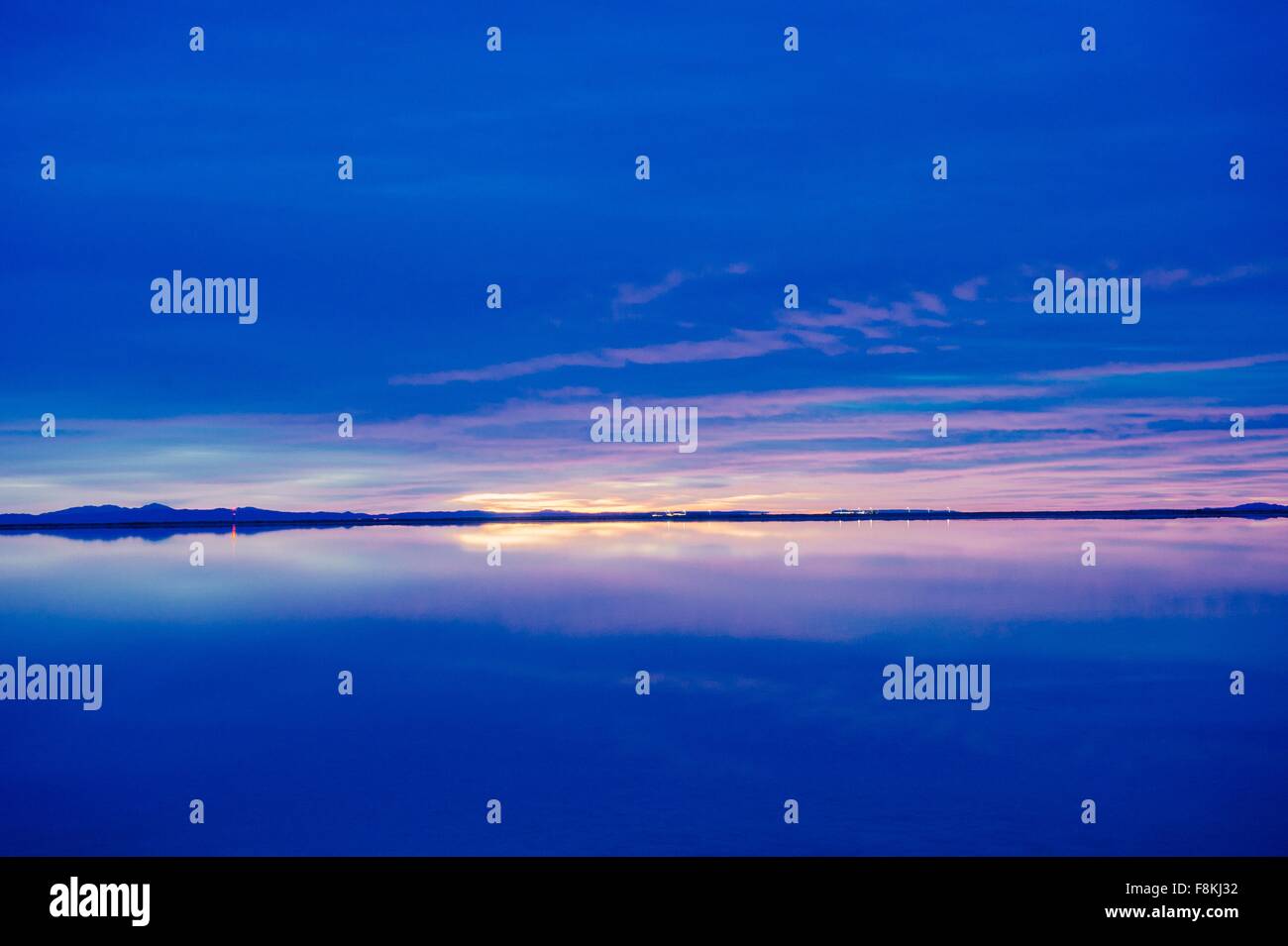 Reflection pool of horizon over water, blue evening sky and sunset, Bonneville, Utah, USA Stock Photo