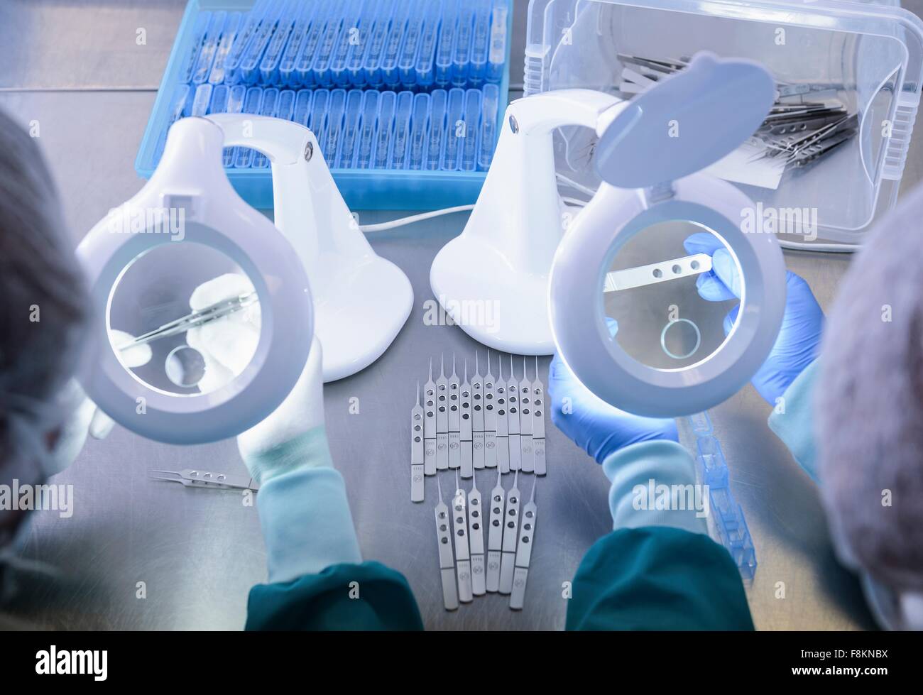 Workers inspecting surgical instruments in clean room of surgical