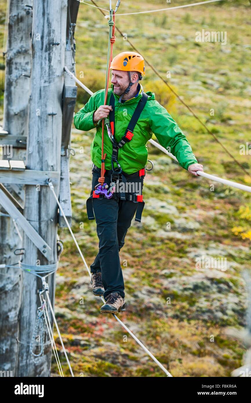Man balancing at high rope access course, Iceland Stock Photo - Alamy