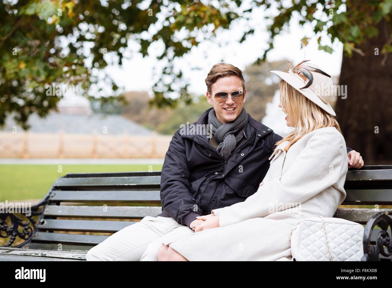 Young couple sitting on park bench, London, England, UK Stock Photo - Alamy