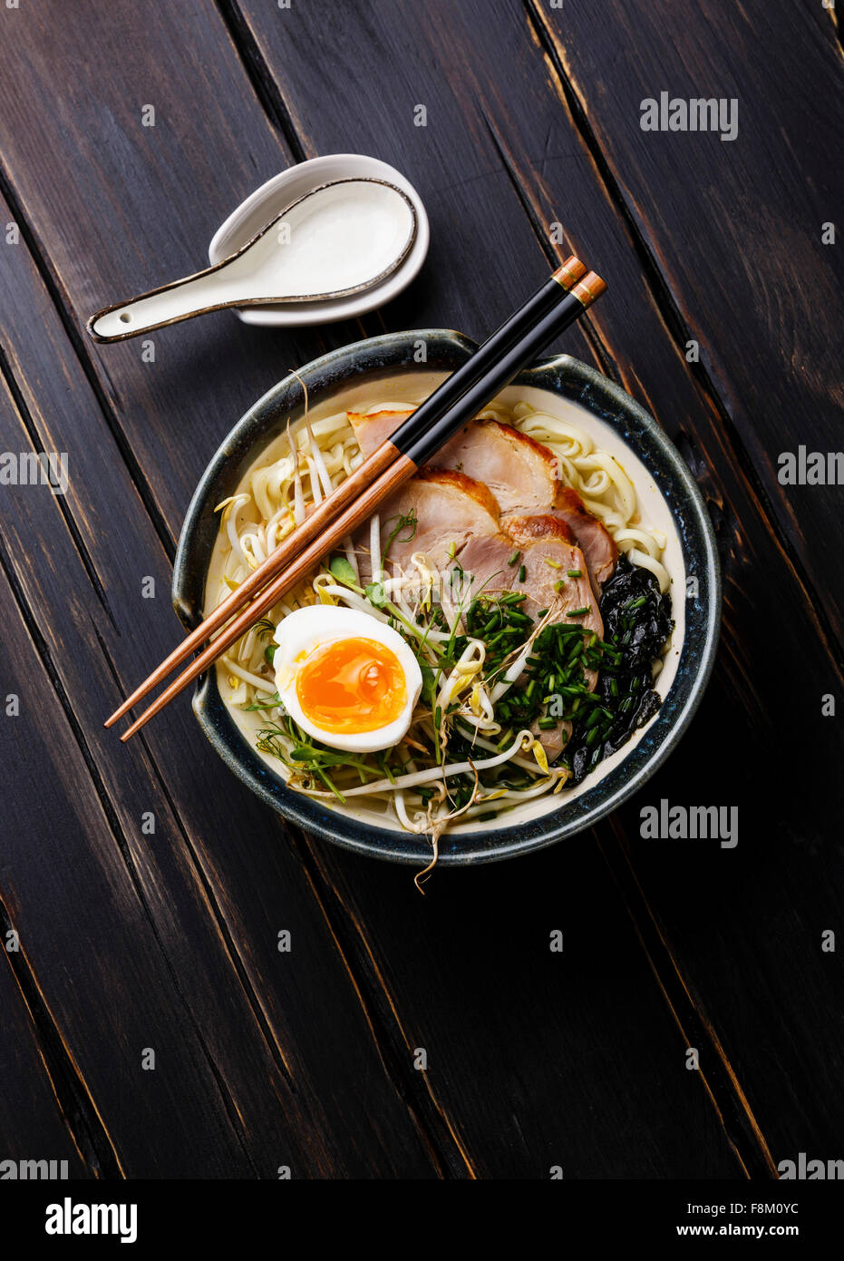 Udon noodle with boiled pork, wheat germ and egg on dark wooden background Stock Photo