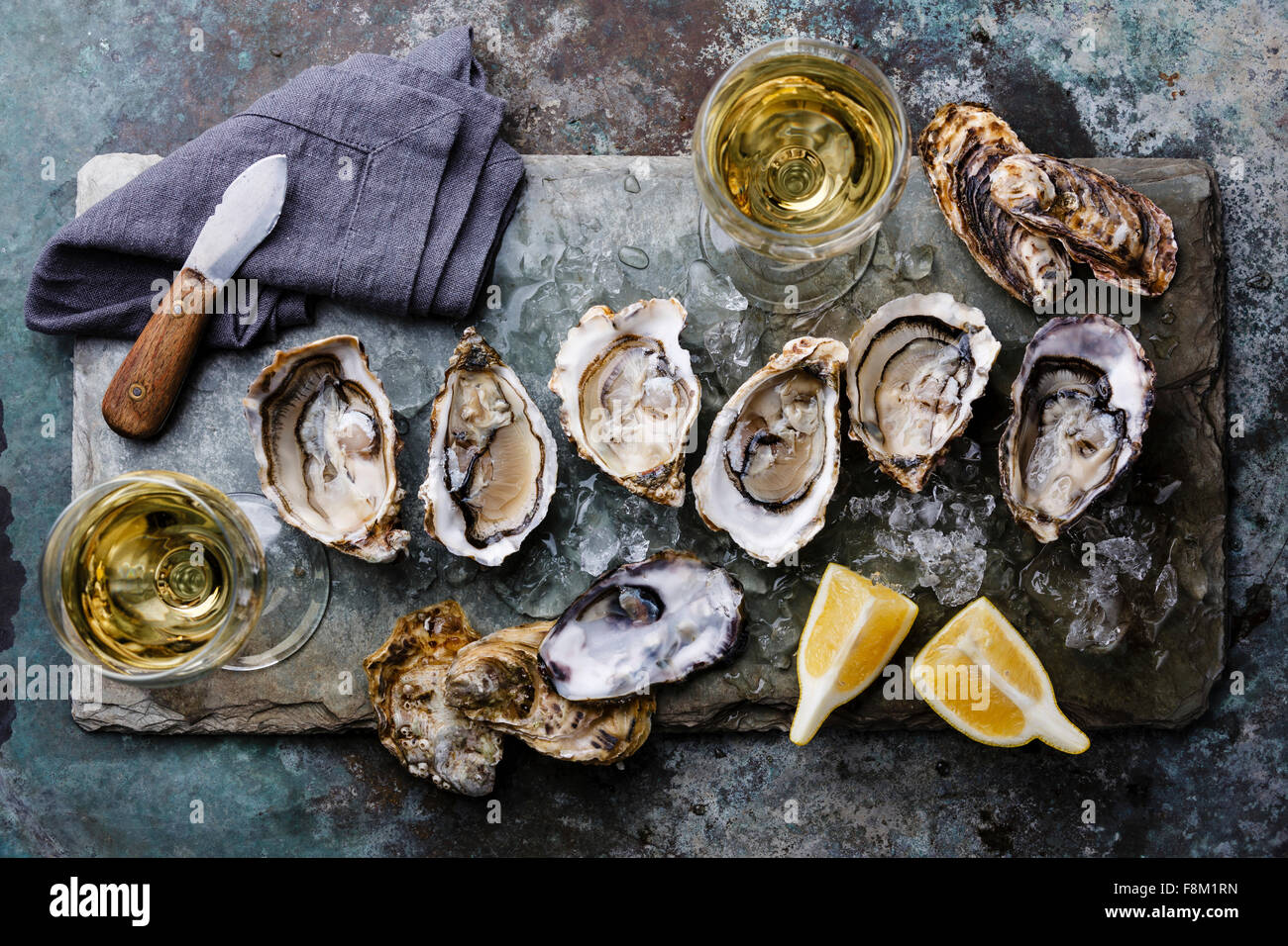 Open Oysters Fines de Claire on stone plate with lemon Stock Photo