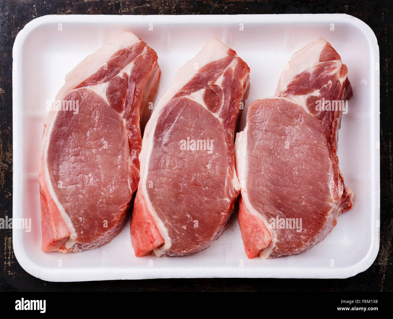 Raw fresh uncooked Pork meat chop steak on bone in white container packaging tray Stock Photo