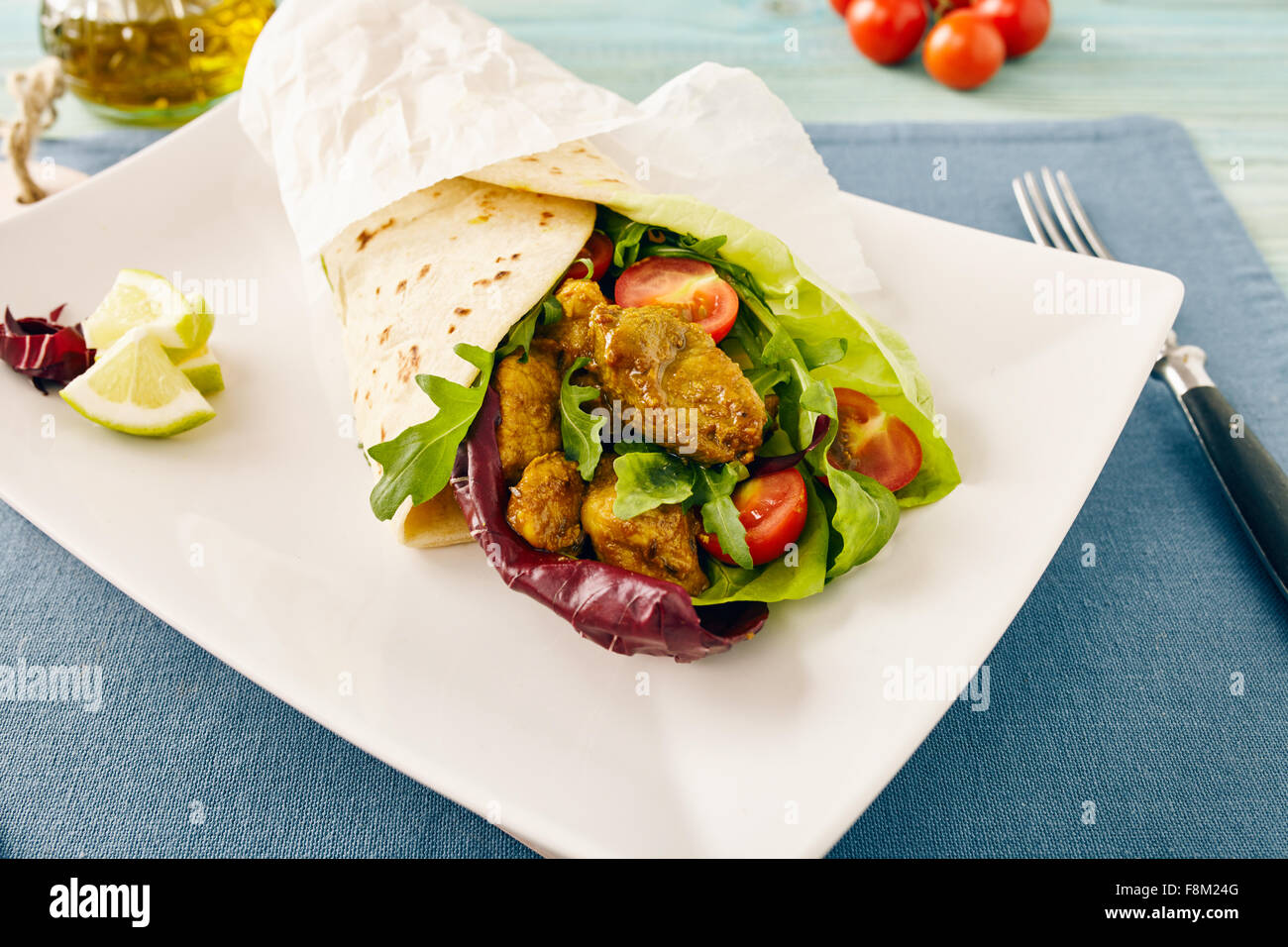 pork wraps on a white serving plate with rocket and lettuce, pastel colors Stock Photo