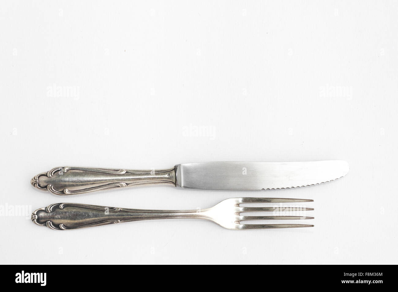 knife, fork - beautiful old  silver cutlery set on white background, copy space Stock Photo