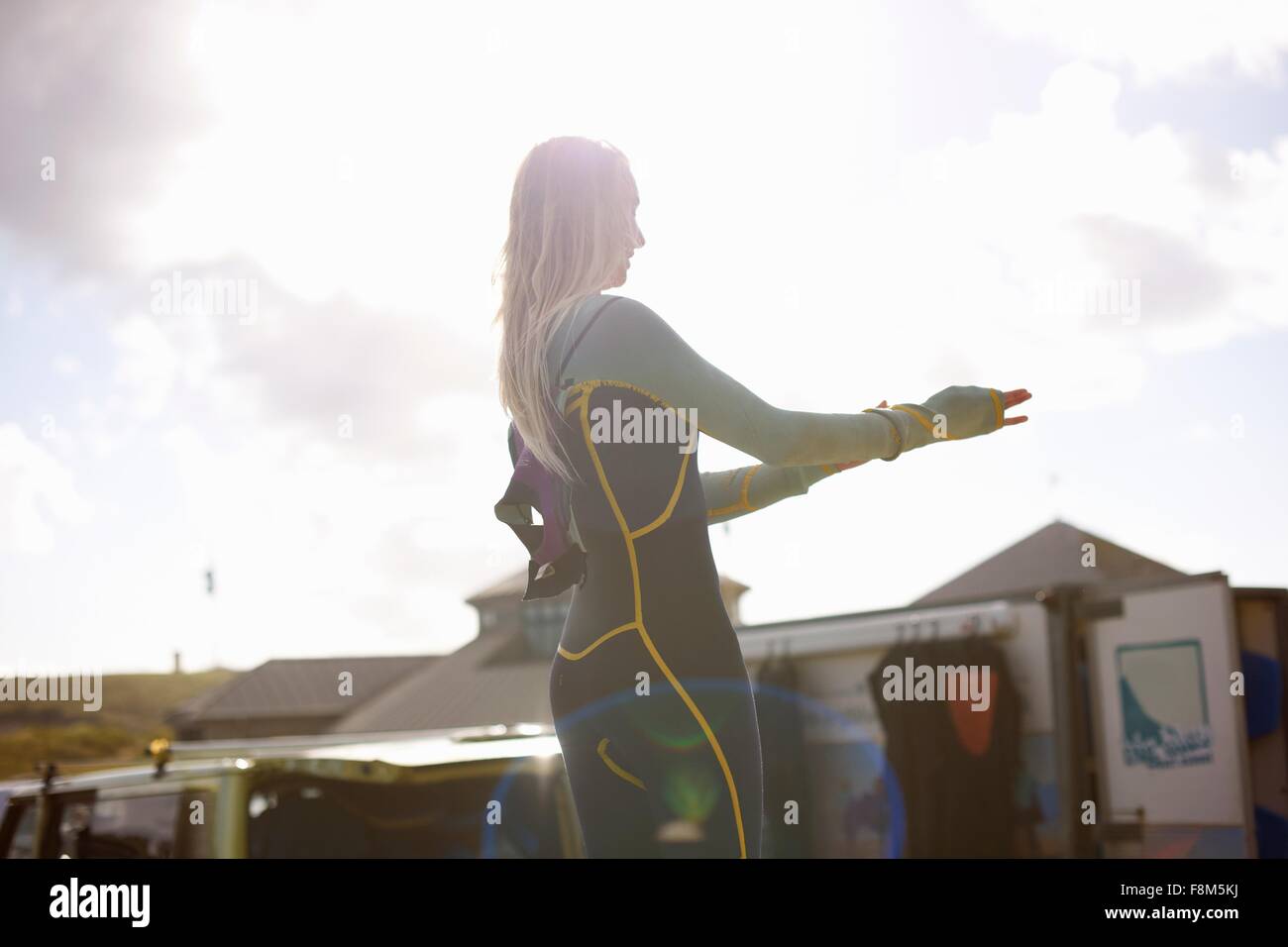 Female surfer putting on wetsuit Stock Photo Alamy