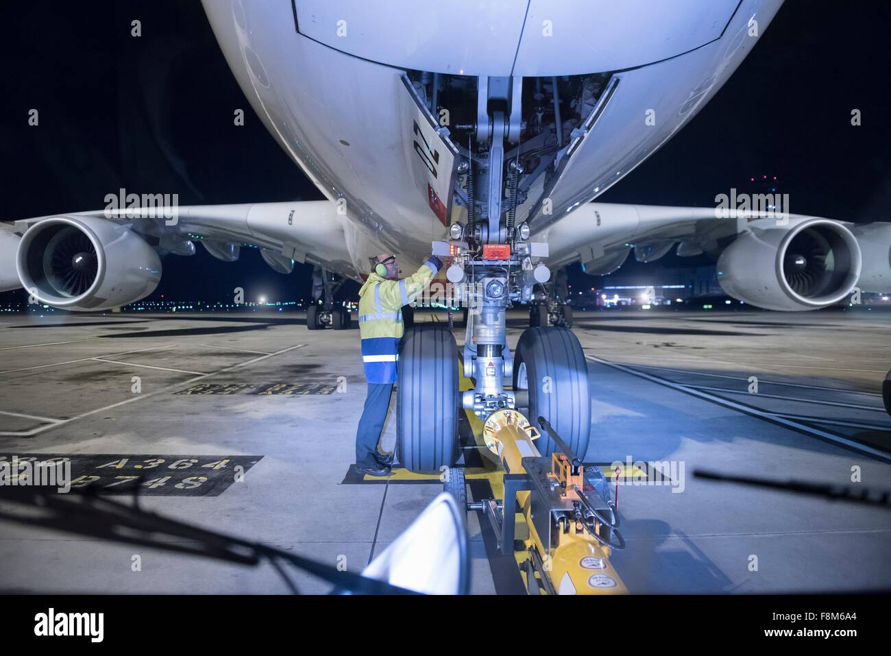 Chief engineer inspecting A380 aircraft on runway at airport at night Stock Photo