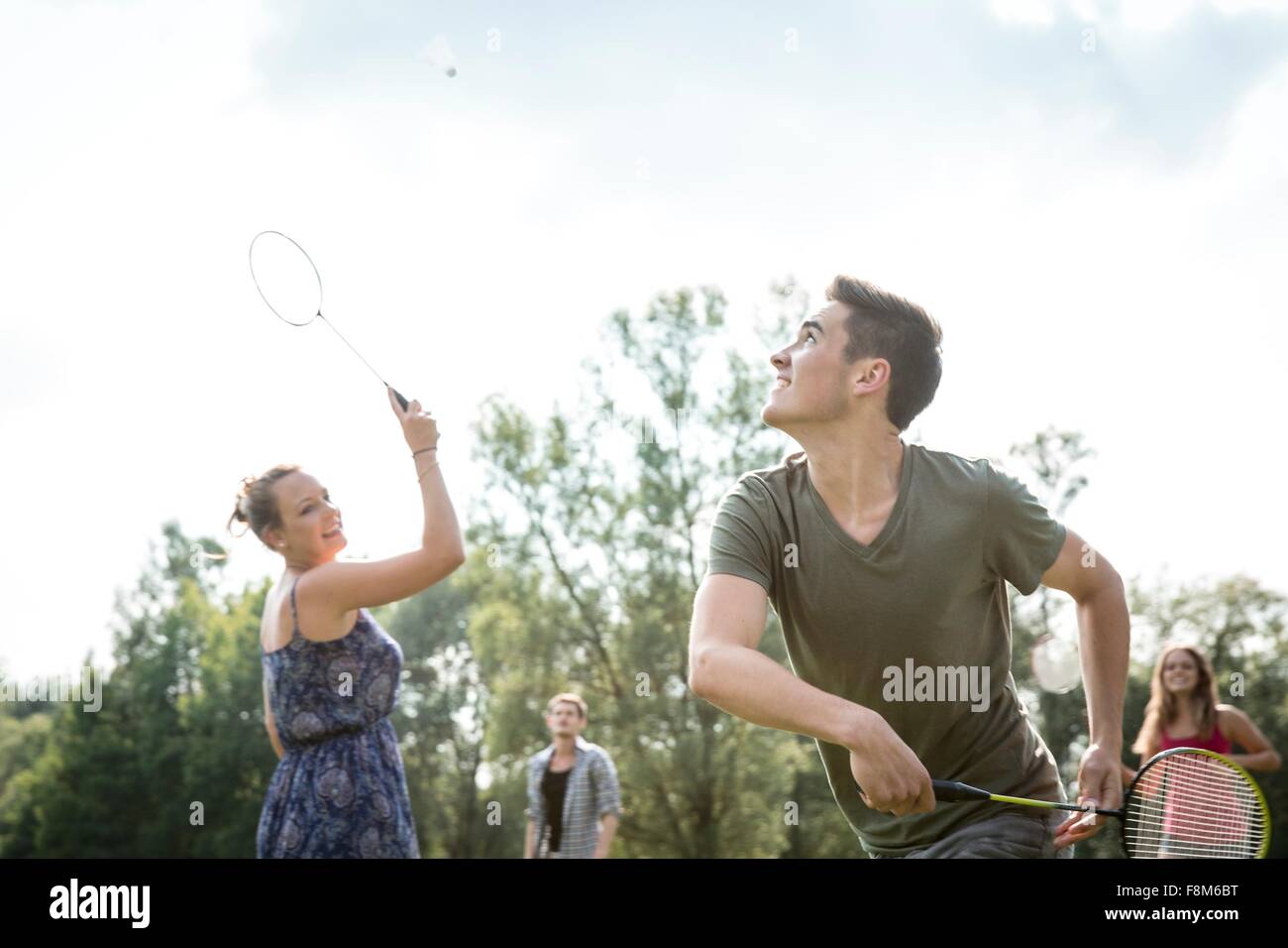 Group of young adults playing badminton in field Stock Photo