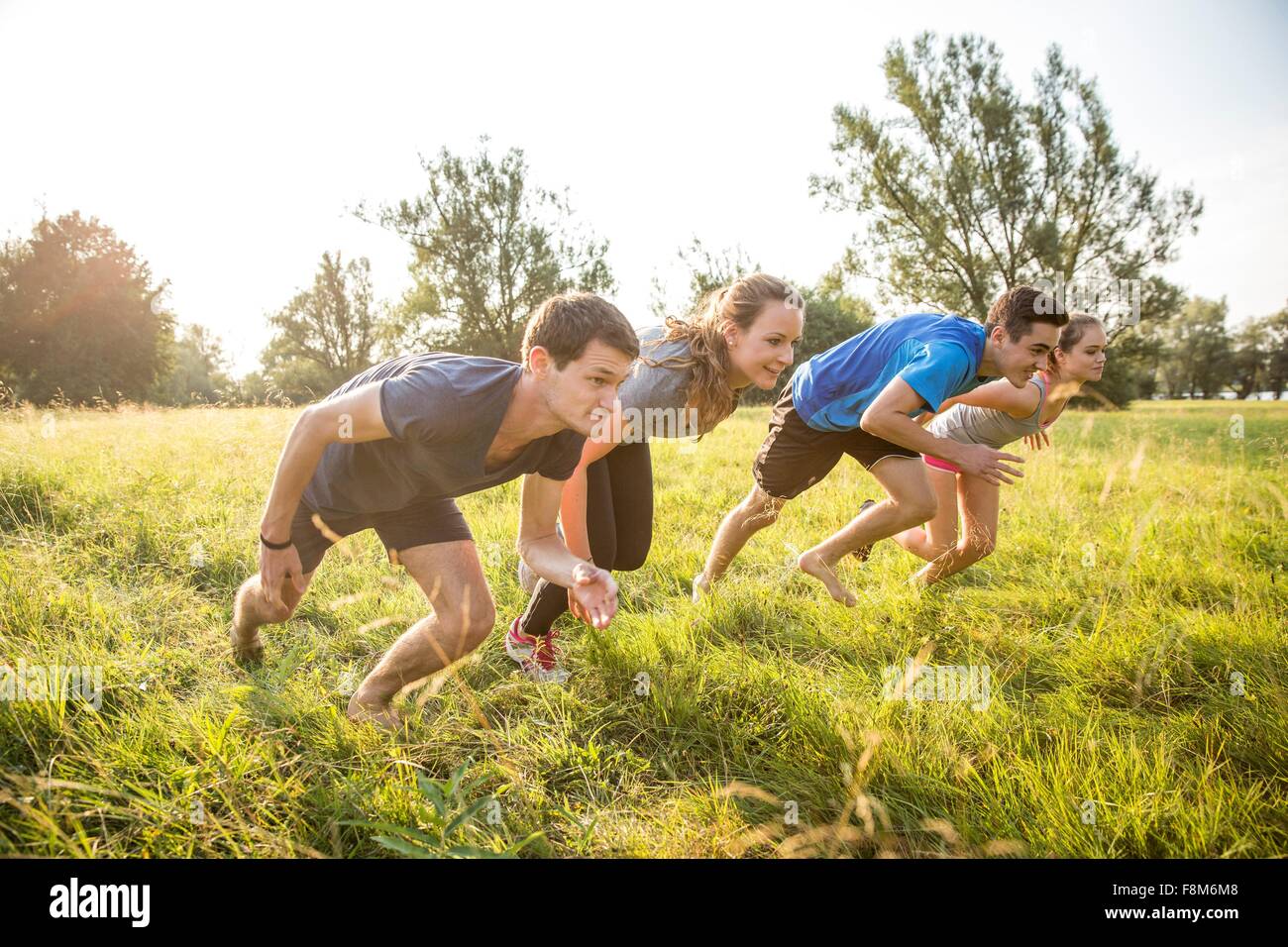 Group of friends running, racing, in field Stock Photo