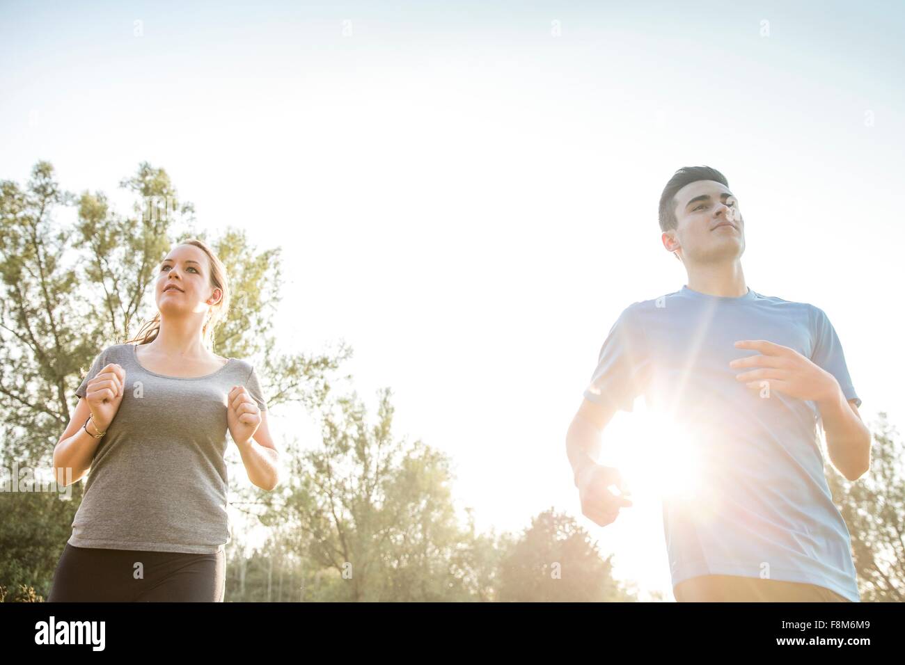 Two young adults, running through field Stock Photo