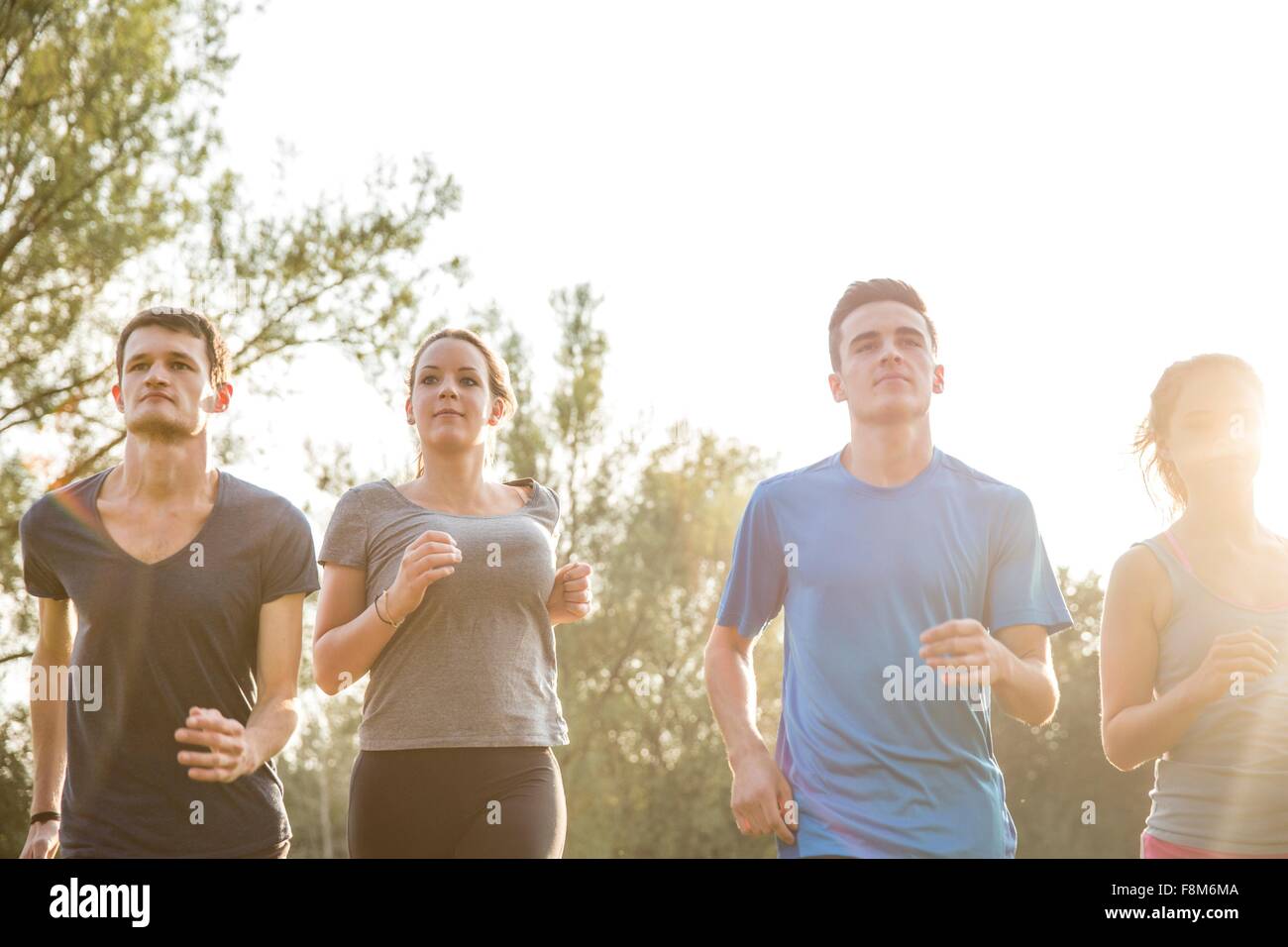 Group of friends running outdoors in rural environment Stock Photo